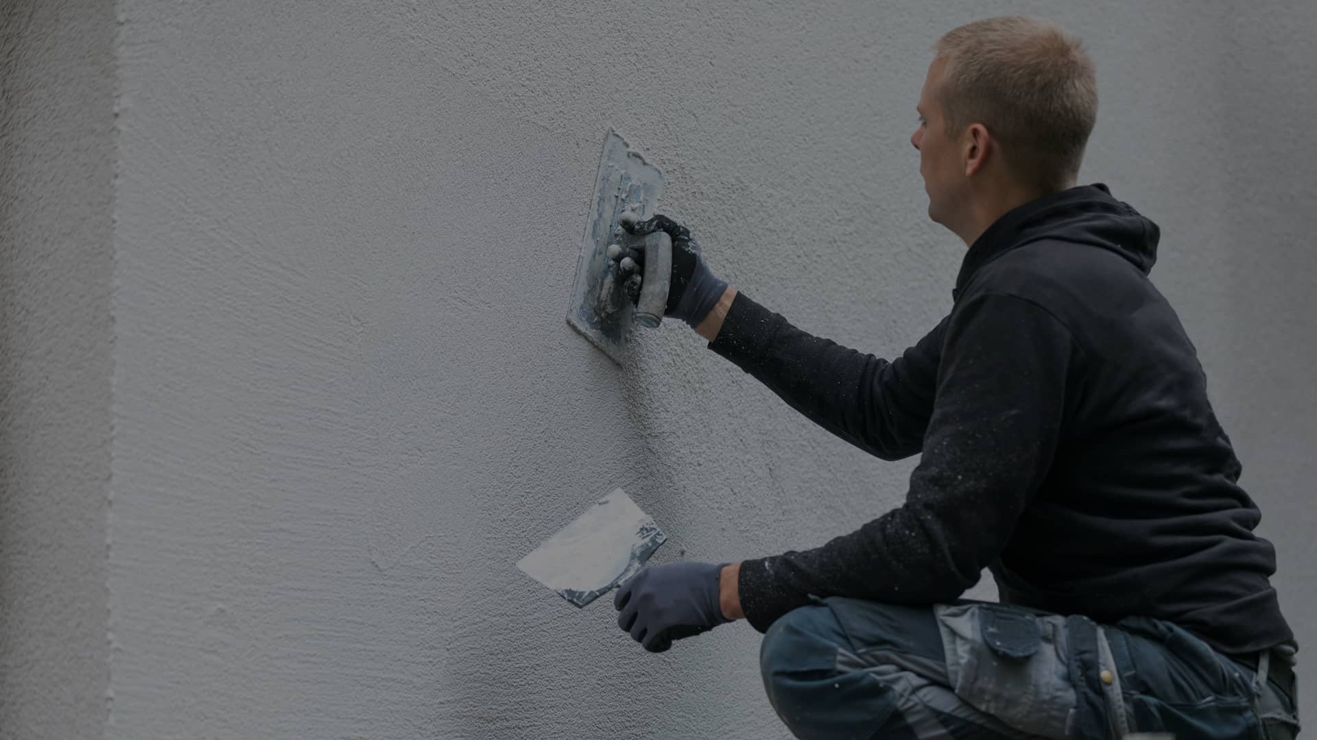 travailleur CAC mettant le plâtre décoratif sur l’extérieur d'un projet résidentiel
