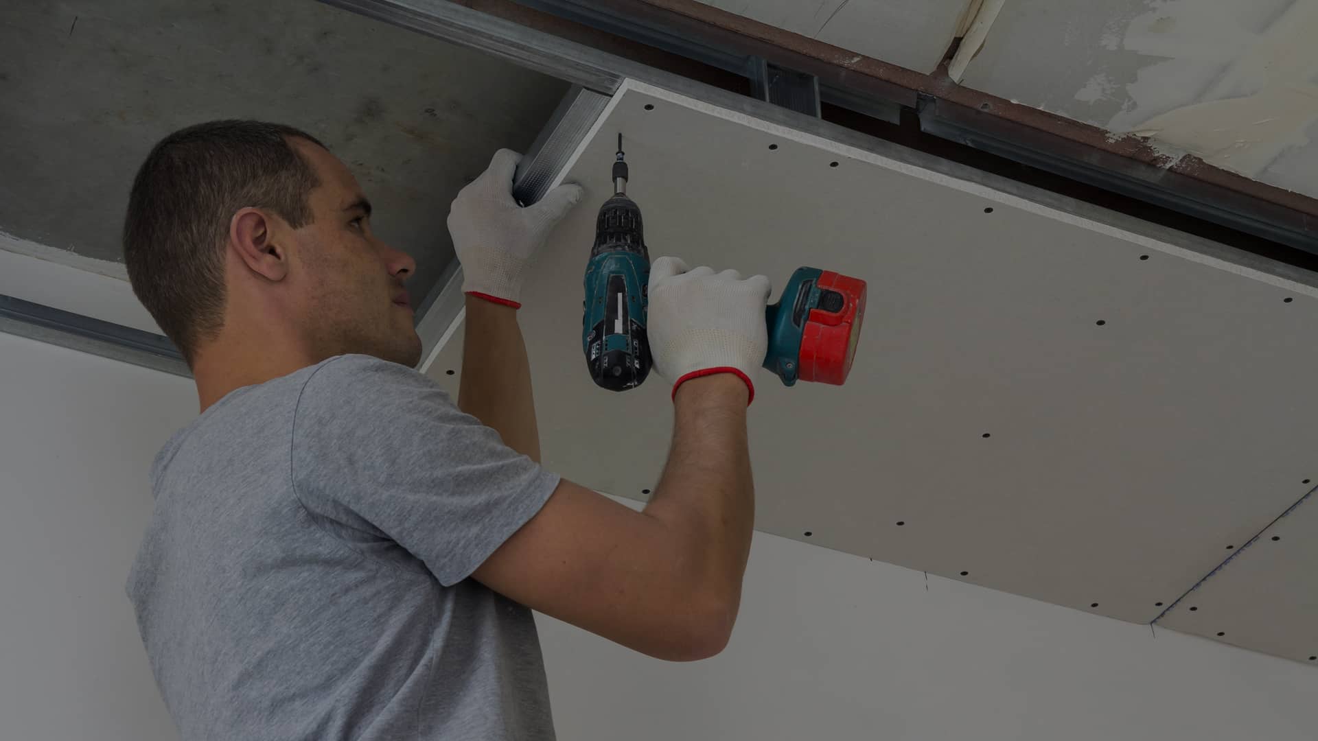 Un travailleur de chez CAC construction assemble un plafond suspendu
